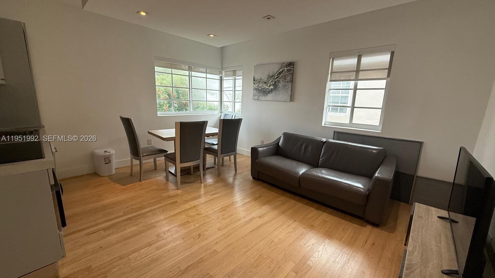 600 15th Street, Unit 9 Miami Beach, FL 33139 - Photo 2 of 12 a living room with furniture a dining table and a window