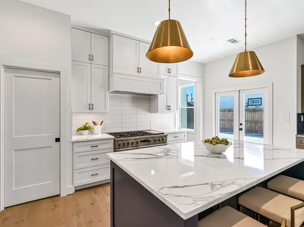 a kitchen that has a lot of cabinets in it and wooden floors