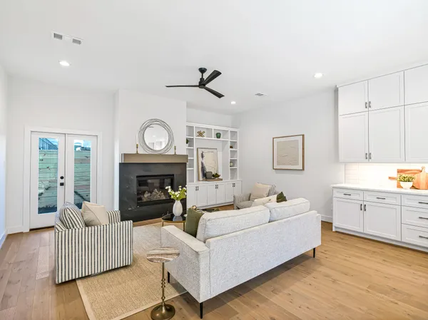 a living room with furniture a clock and a fireplace