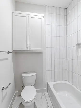 a bathroom with a granite countertop sink a toilet and a mirror