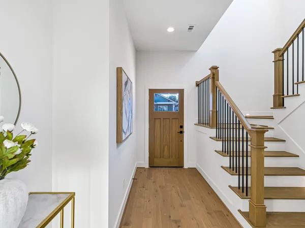 a view of a hallway with wooden floor and staircase