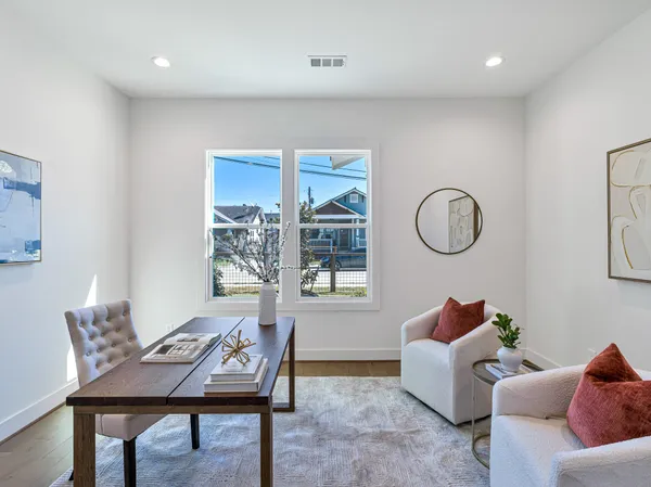 a living room with furniture a window and a potted plant