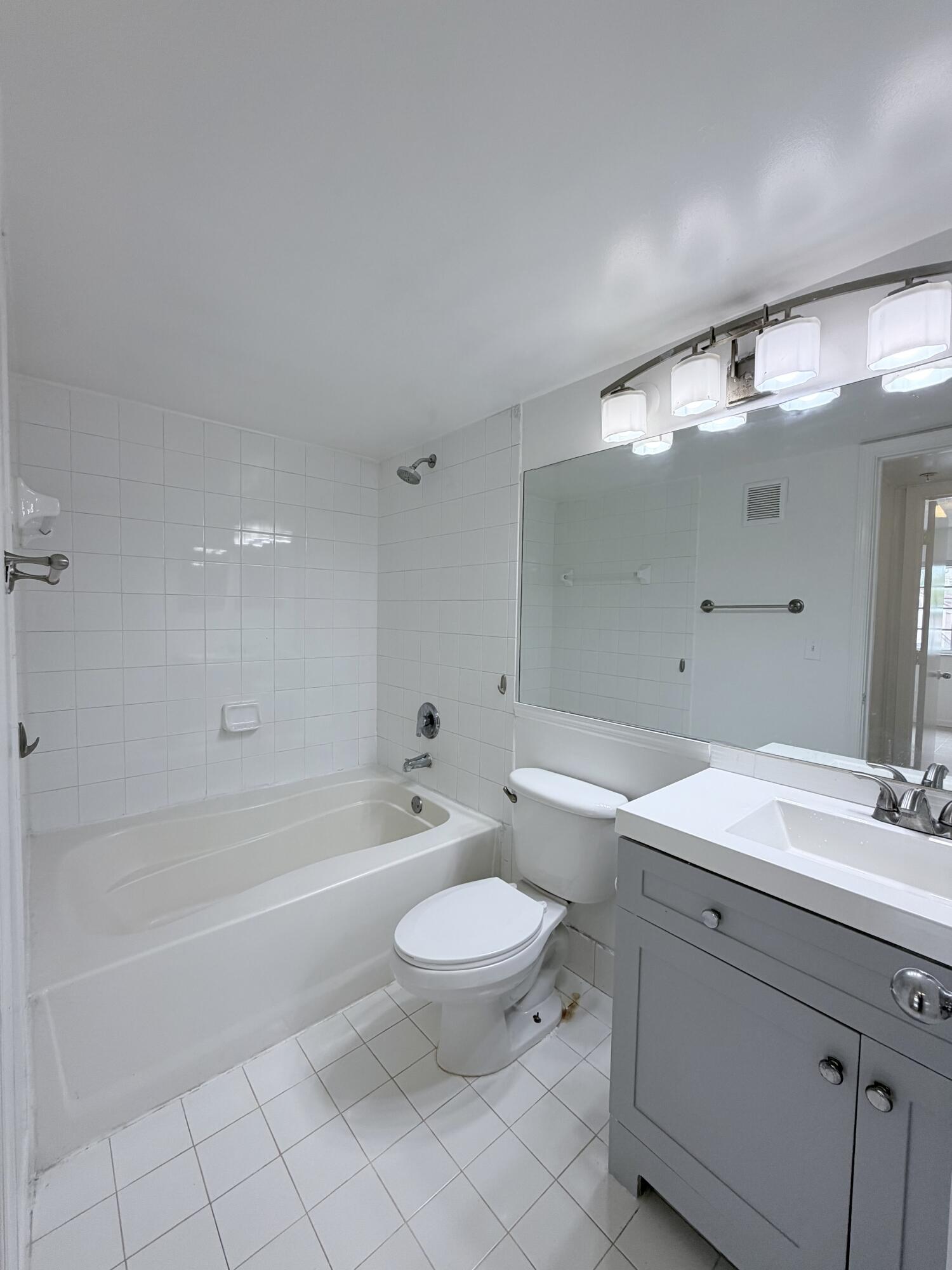 2041 Renaissance Boulevard, Unit 207 Miramar, FL 33025 - Photo 8 of 11 a bathroom with a sink a toilet and a large mirror