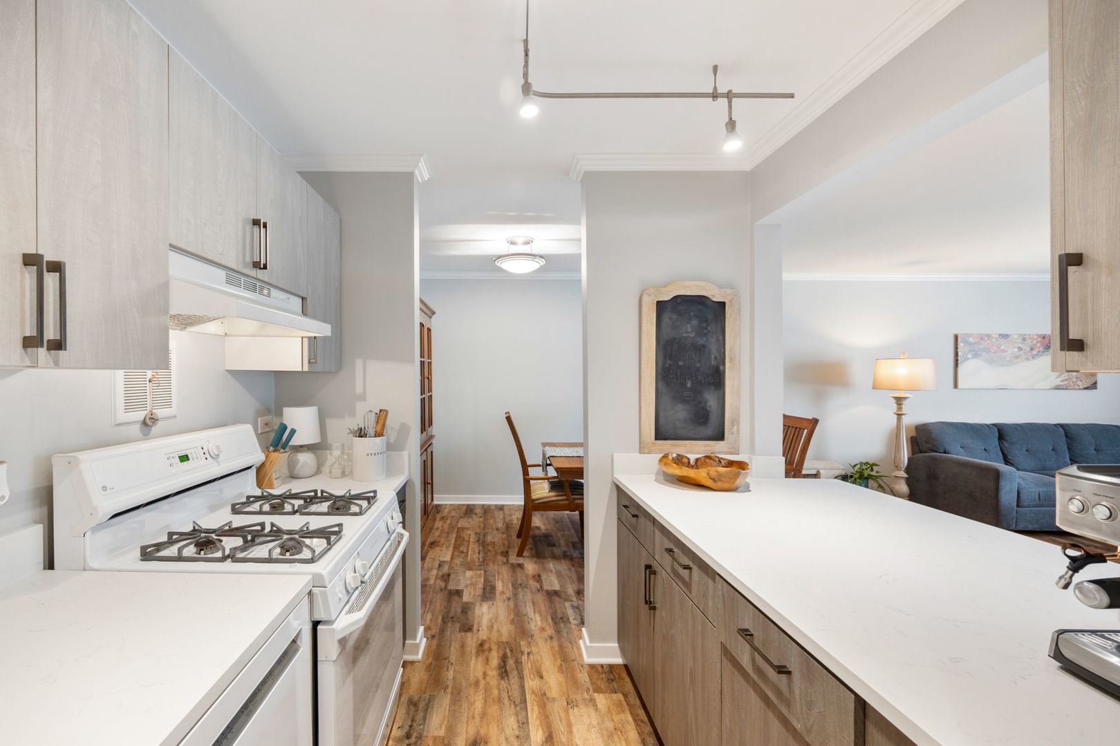1127 South Old Wilke Road, Unit 203 Rolling Meadows, IL 60005 - Photo 10 of 13 a large white kitchen with a stove a sink a dining table and chairs