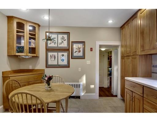 5 Pond Circle Boston, MA 02130 - Photo 9 of 27 a living room with stainless steel appliances kitchen island granite countertop a refrigerator a sink dishwasher with couches and dining table with wooden floor
