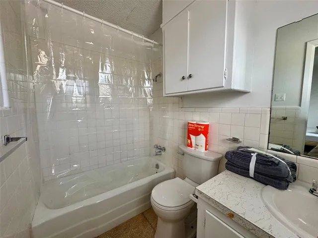 a bathroom with a granite countertop toilet a sink and bathtub