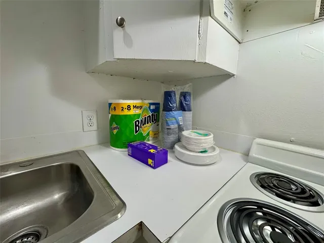 a kitchen with a sink and a stove with white countertops