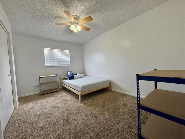 a bedroom with a bed and a ceiling fan