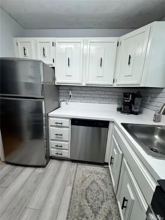 a kitchen with cabinets appliances and a sink