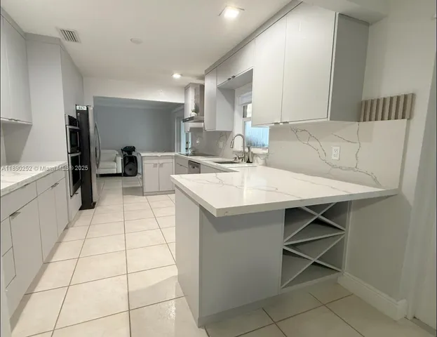 a large white kitchen with a white table and chairs