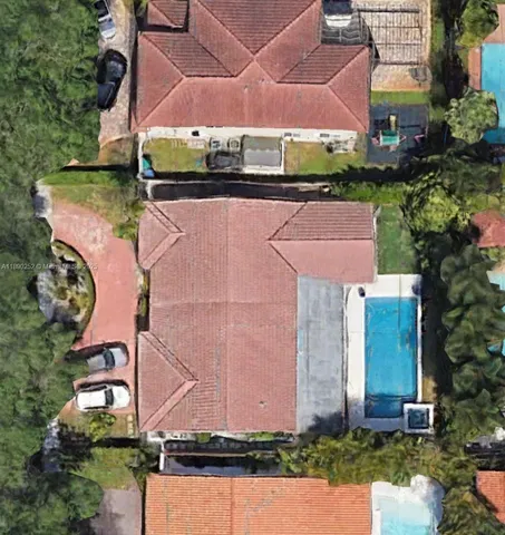 an aerial view of a house with a yard and a large tree