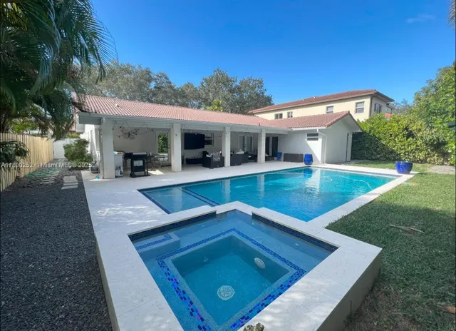 a view of a house with pool and a yard