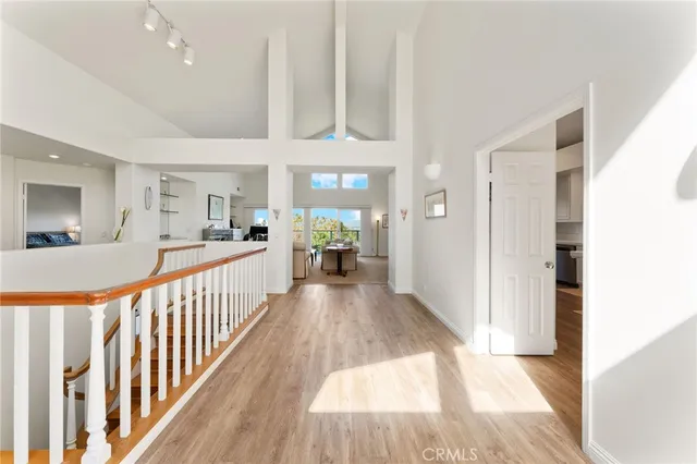 a view of a dining room with furniture a chandelier and large windows
