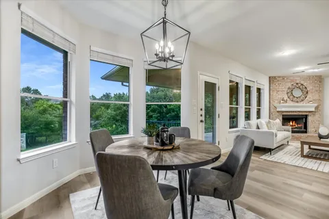 a dining room with furniture a chandelier and wooden floor