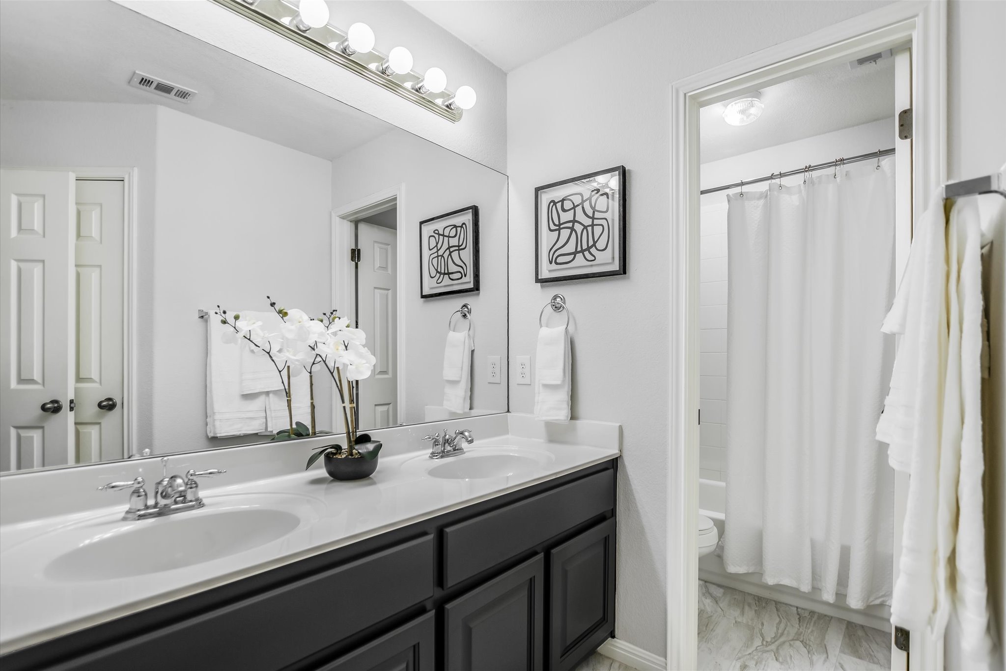 9409 Lisi Anne Drive Austin, TX 78717 - Photo 19 of 25 a bathroom with a double vanity sink and a mirror