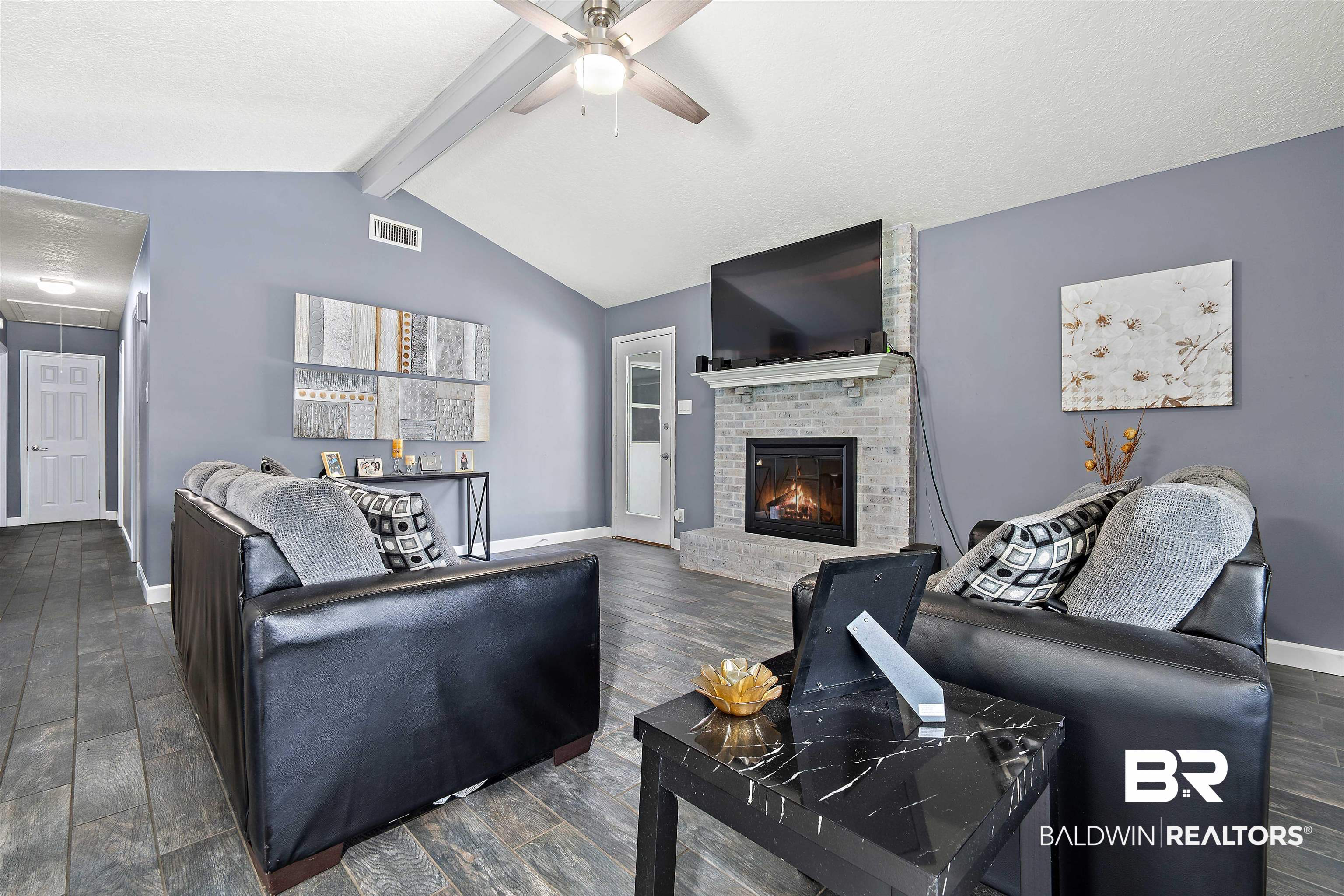 2000 Campfire Drive Semmes, AL 36575 - Photo 5 of 26 Living room with a fireplace, ceiling fan, dark hardwood / wood-style flooring, brick wall, and lofted ceiling with beams