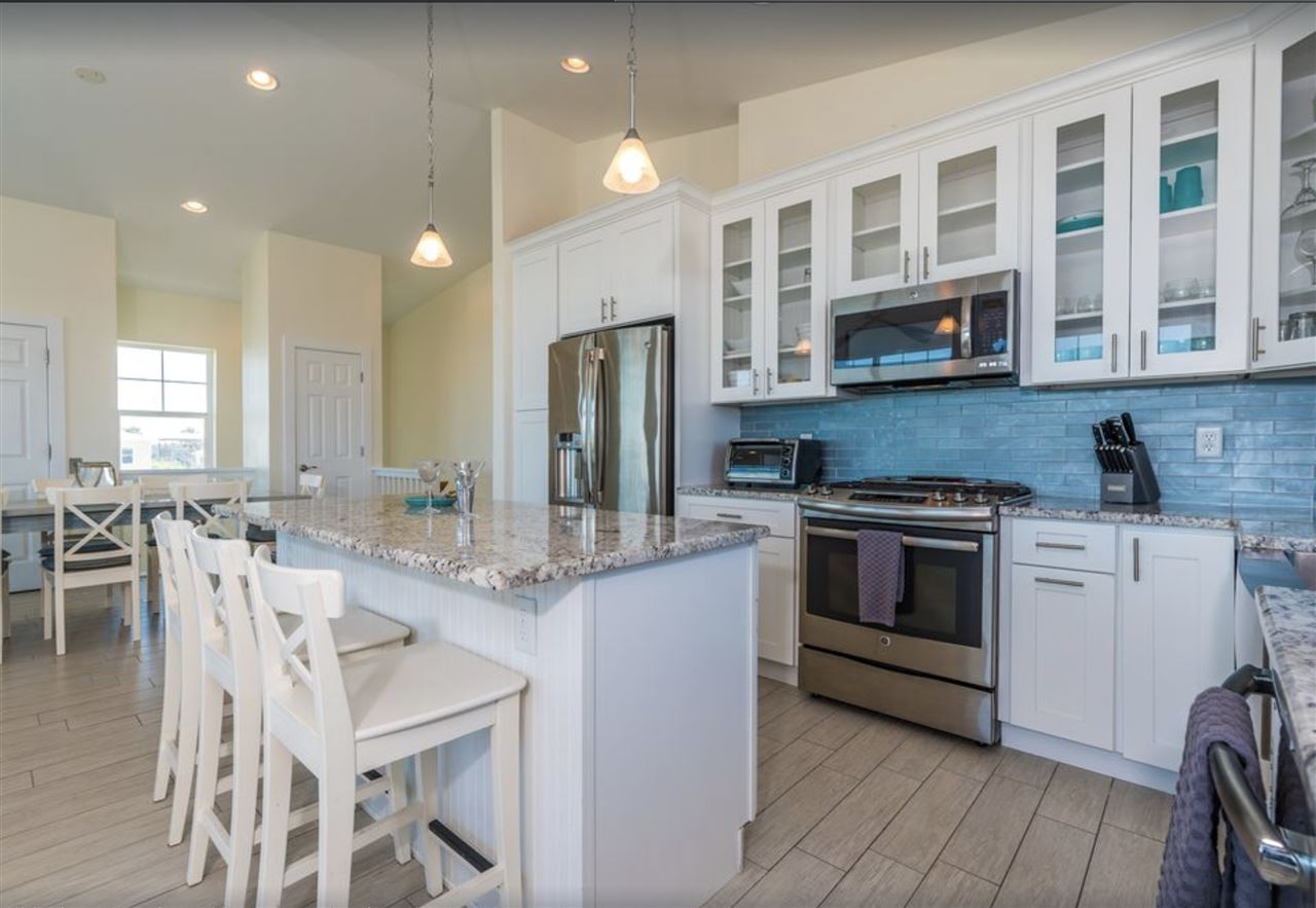 5349 Atlantic View St. Augustine, FL 32080 - Photo 8 of 33 a kitchen with stainless steel appliances granite countertop a stove a sink dishwasher a refrigerator and a dining table with wooden floor