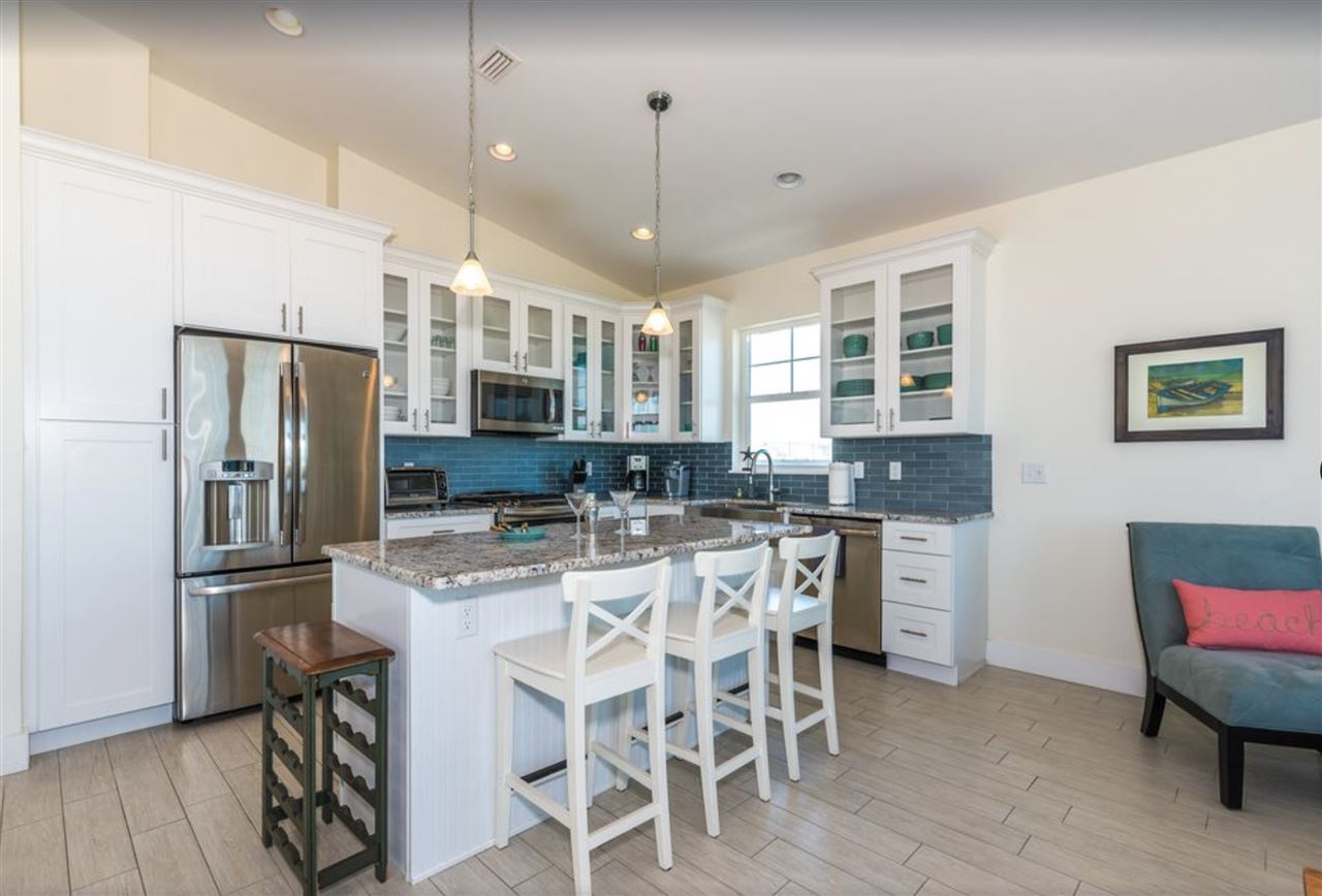 5349 Atlantic View St. Augustine, FL 32080 - Photo 9 of 33 a kitchen with stainless steel appliances granite countertop a dining table chairs refrigerator and cabinets