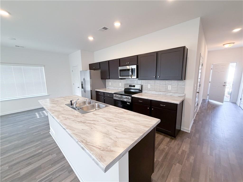 145 Red Oak Lane Calhoun, GA 30701 - Photo 4 of 18 a kitchen with stainless steel appliances kitchen island granite countertop a kitchen island a stove a refrigerator a sink a dining table and chairs
