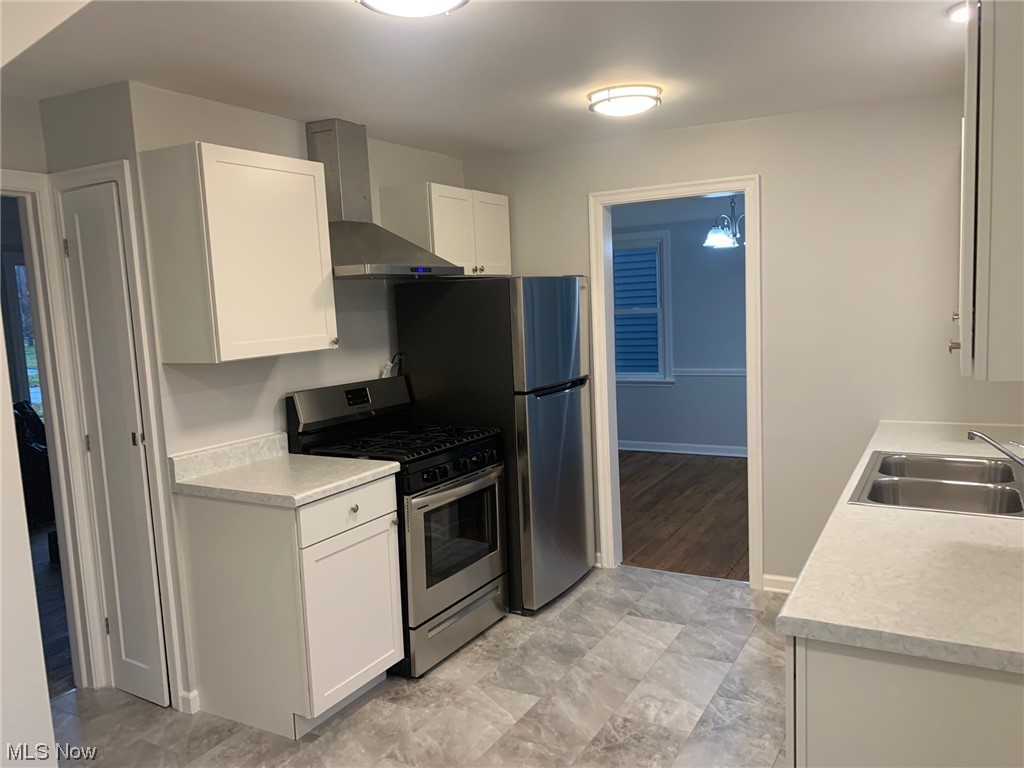 1456 Evanston Road Lyndhurst, OH 44124 - Photo 5 of 32 Kitchen with gas range, white cabinetry, light tile floors, and wall chimney exhaust hood