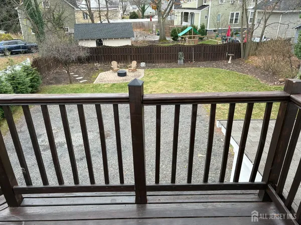 a view of a backyard with table and chairs with wooden fence and plants