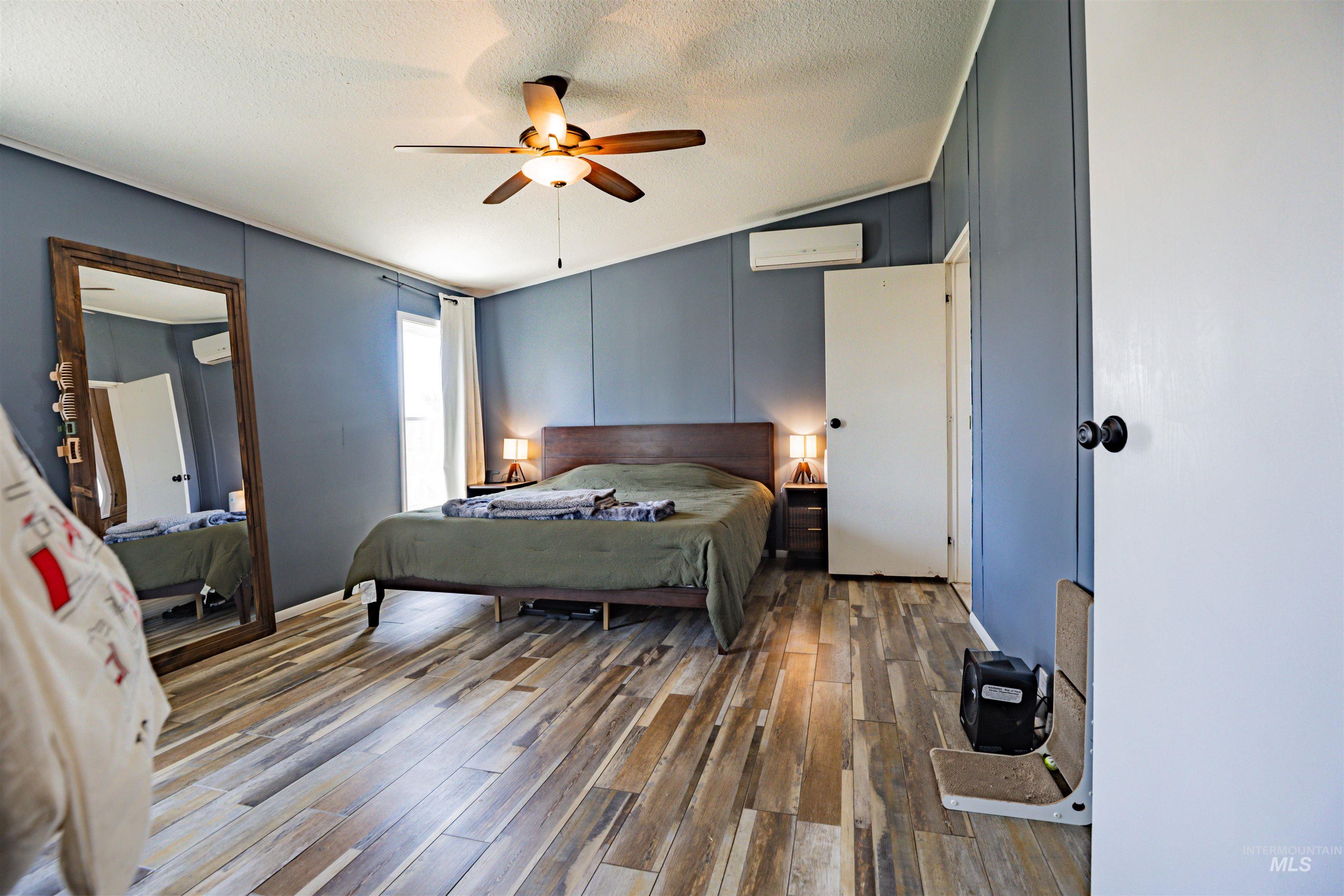 23904 Southview Lane Middleton, ID 83644 - Photo 29 of 29 Room featuring wood-finish flooring, a ceiling fan with integrated lighting, and a wall-mounted mini-split HVAC unit