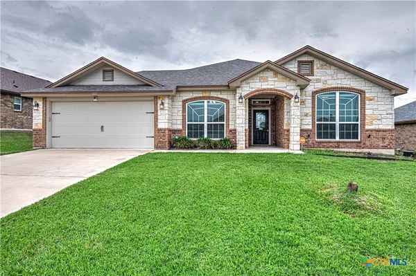 a front view of a house with a yard and garage
