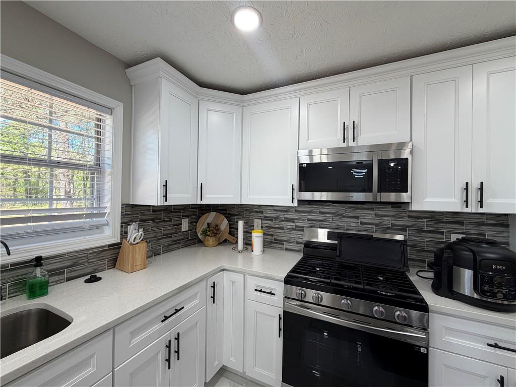 934 Bay Ridge Drive Lawrenceville, GA 30045 - Photo 44 of 78 a kitchen with stainless steel appliances granite countertop a sink stove and cabinets