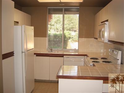 401 El Cielo Road, Unit 227 Palm Springs, CA 92262 - Photo 8 of 24 a kitchen with kitchen island a window a sink and a refrigerator