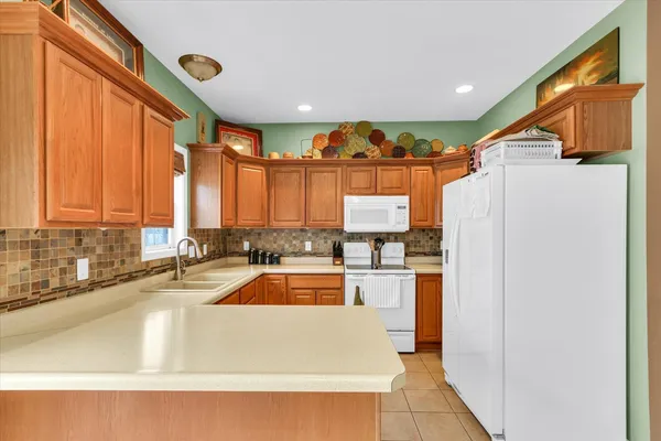 a kitchen with large windows and refrigerator