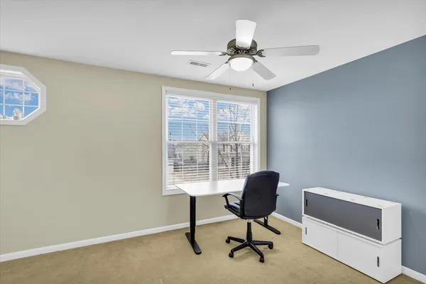 a view of a workspace with furniture and a window