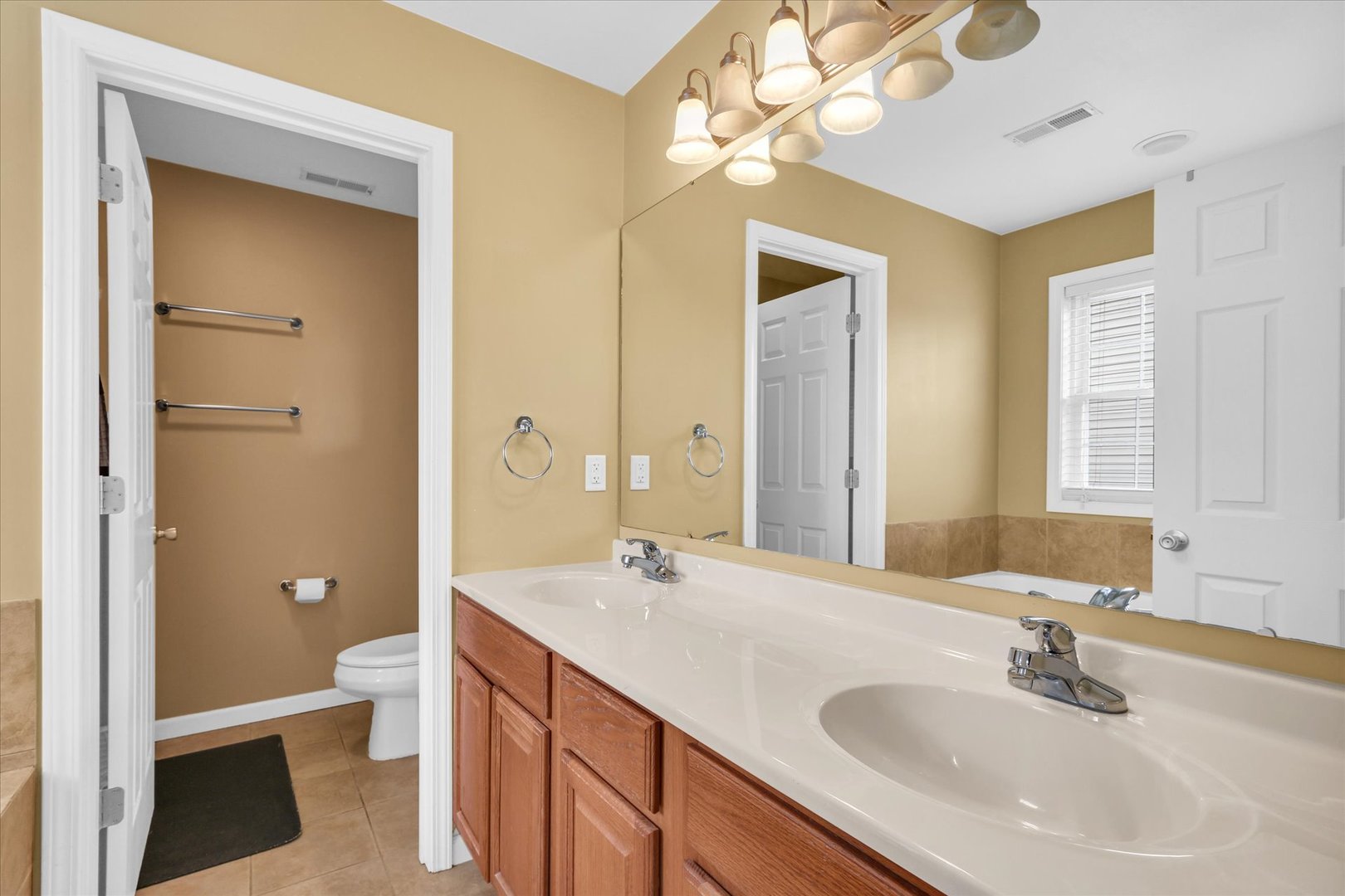 1328 West Ridge Lane Champaign, IL 61822 - Photo 29 of 41 a bathroom with a sink a toilet and a large mirror