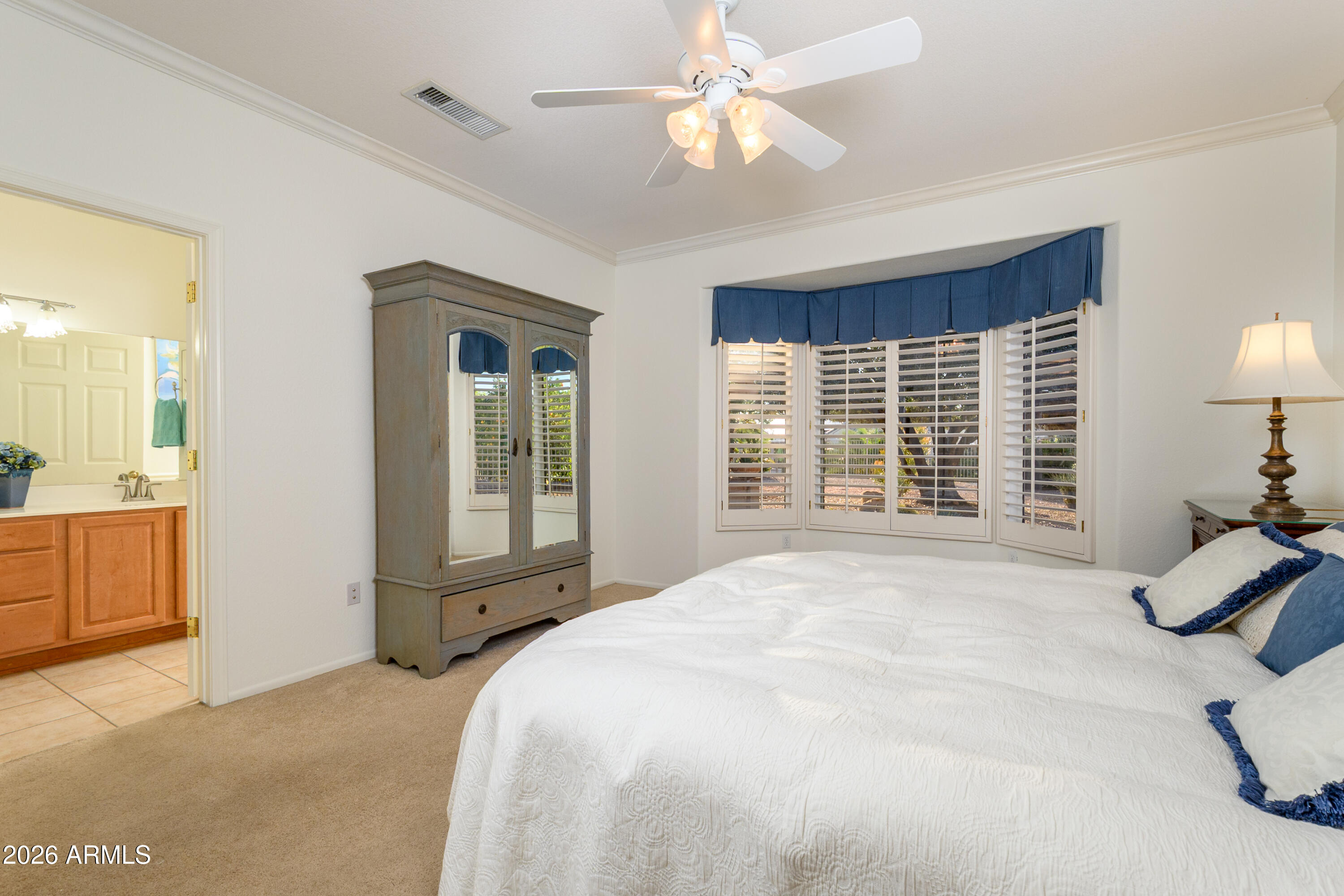 15883 West Cisa Rio Lane Surprise, AZ 85374 - Photo 27 of 45 a spacious bedroom with a large bed a chandelier and windows