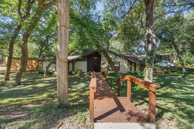 a front view of a house with a tree