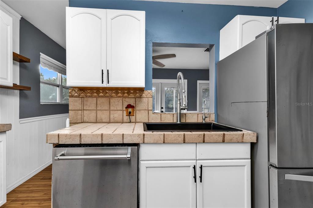 29341 Passion Flower Street Punta Gorda, FL 33982 - Photo 18 of 68 a kitchen with kitchen island a refrigerator a sink and white cabinets