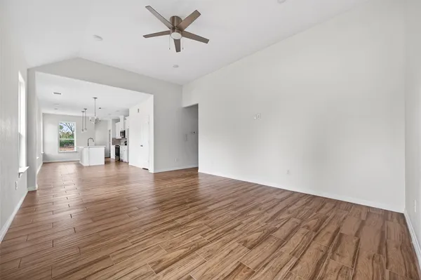 a view of a livingroom with wooden floor and a ceiling fan