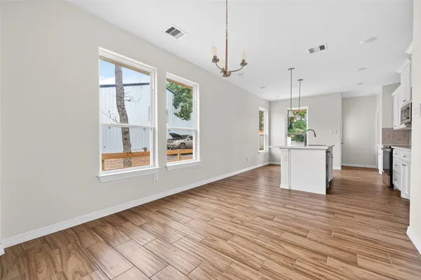a view of a kitchen with wooden floor and a window