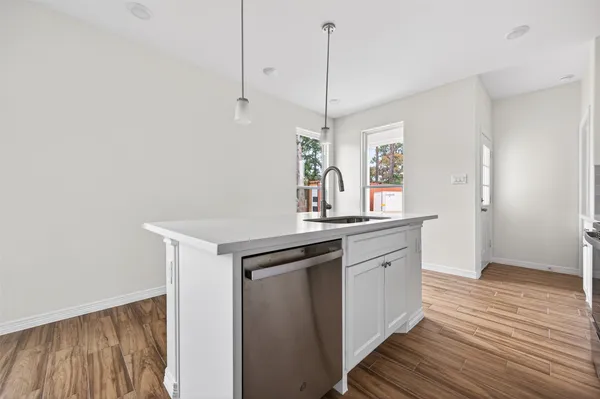 a kitchen with a sink a refrigerator and wooden floor