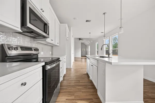 a kitchen with stainless steel appliances granite countertop a stove top oven a sink and dishwasher