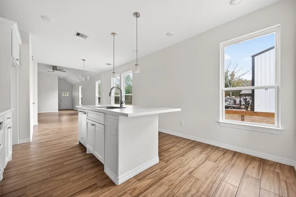 a kitchen with granite countertop white cabinets and stainless steel appliances