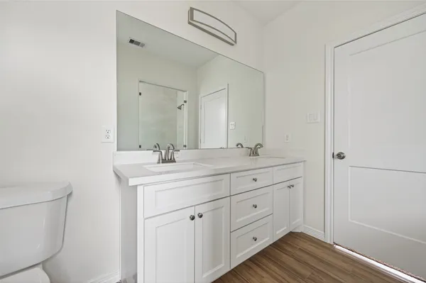 a spacious bathroom with a granite countertop sink a mirror and a shower