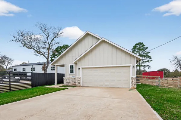 a front view of house with yard and trees in the background