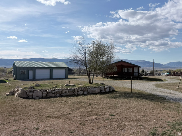220 South 600 East Spring City, UT 84662 - Photo 1 of 1 View of yard featuring a mountain view, an outbuilding, and a garage