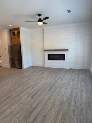 a view of empty room with wooden floor