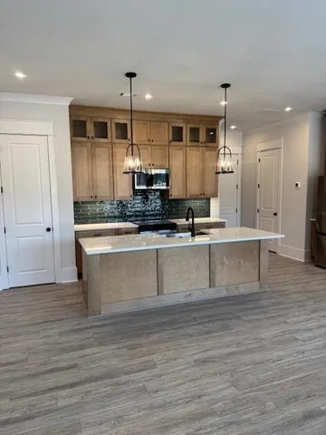 a large kitchen with kitchen island a sink stainless steel appliances and cabinets