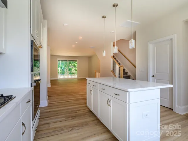 a kitchen with a sink and wooden floor