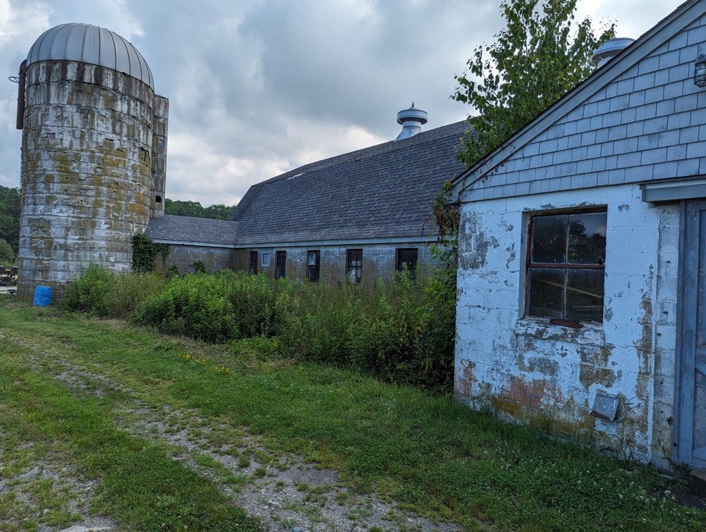 228 E Road Tiverton, RI 02878 - Photo 17 of 27 a view of a brick house with a small yard and a large tree