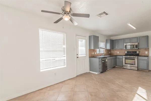 a kitchen with a refrigerator sink and cabinets