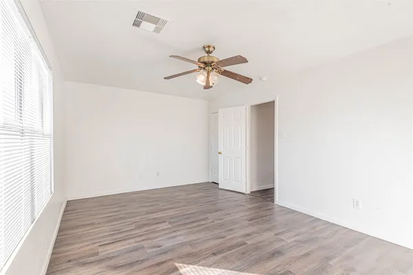 a view of a room with wooden floor and a ceiling fan