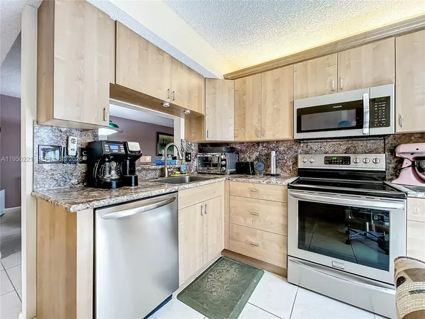 a kitchen with stainless steel appliances granite countertop a stove microwave and cabinets
